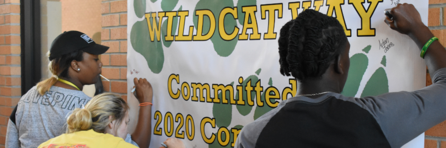 Students signing wildcat banner