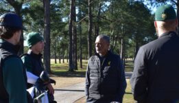 Golf team speaking with Coach Davis