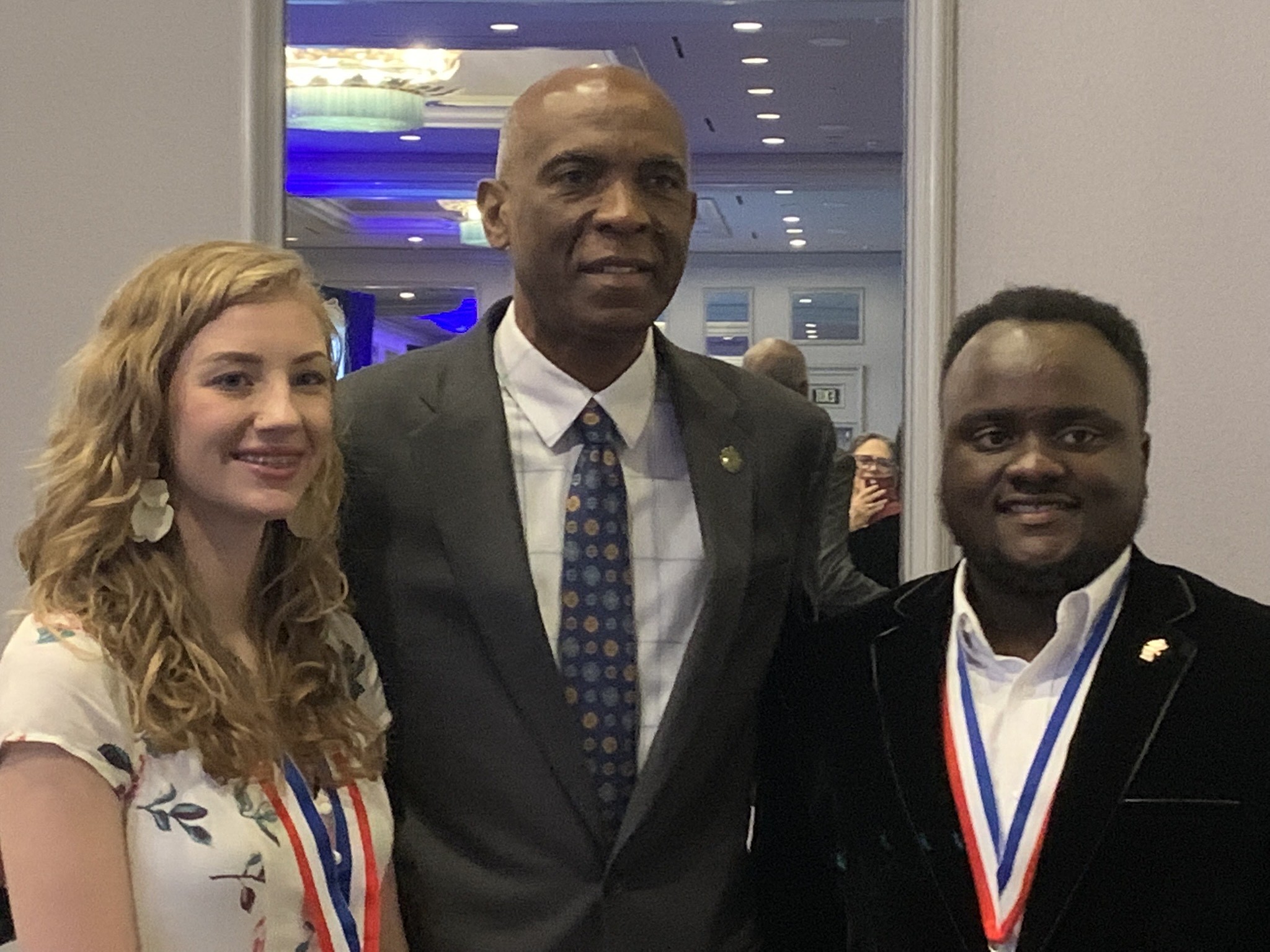 two students pose for picture with interim president